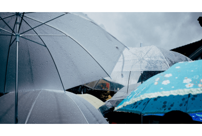 Pessoas usando guarda chuva durante uma chuva.