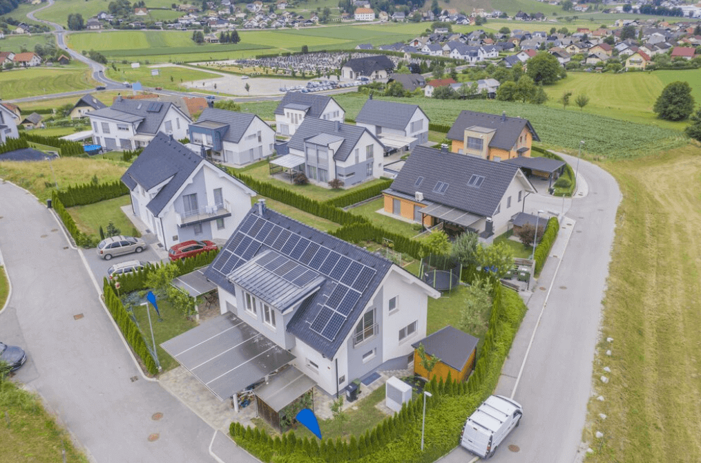 Vista de cima de uma cidade com casas com placas solares nos telhados